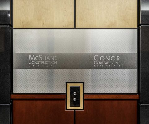 Branded stainless steel accents in elevator lobby
